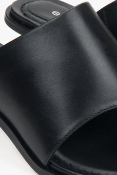 Black leather stiletto mules with a toe ring – details.