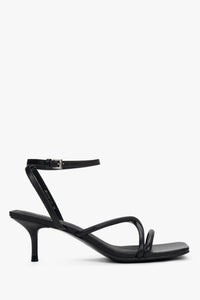 Women’s black leather stiletto sandals by Estro with thin crossing straps.
