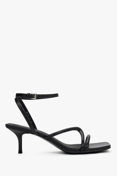 Women’s black leather stiletto sandals by Estro with thin crossing straps.