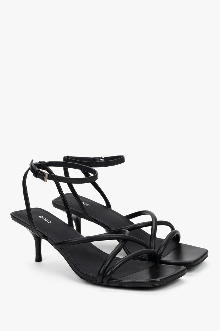Side view of women’s black stiletto sandals with slim leather straps.
