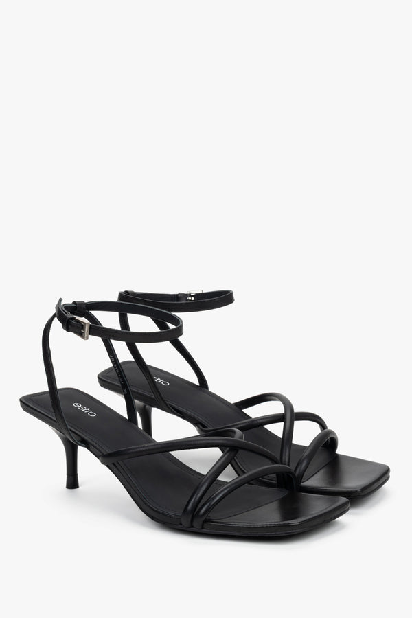 Side view of women’s black stiletto sandals with slim leather straps.
