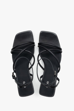 Top view of women’s black leather stiletto sandals with square toe.