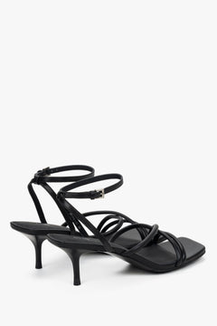 Detail view of soft crossing straps on black leather Estro sandals.