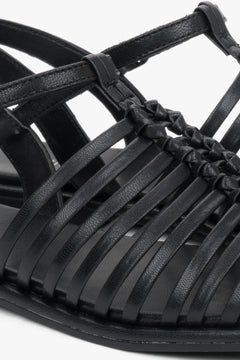 Flat black summer sandals with thin leather straps and buckle closure.