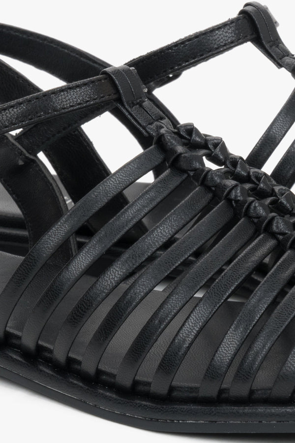 Flat black summer sandals with thin leather straps and buckle closure.