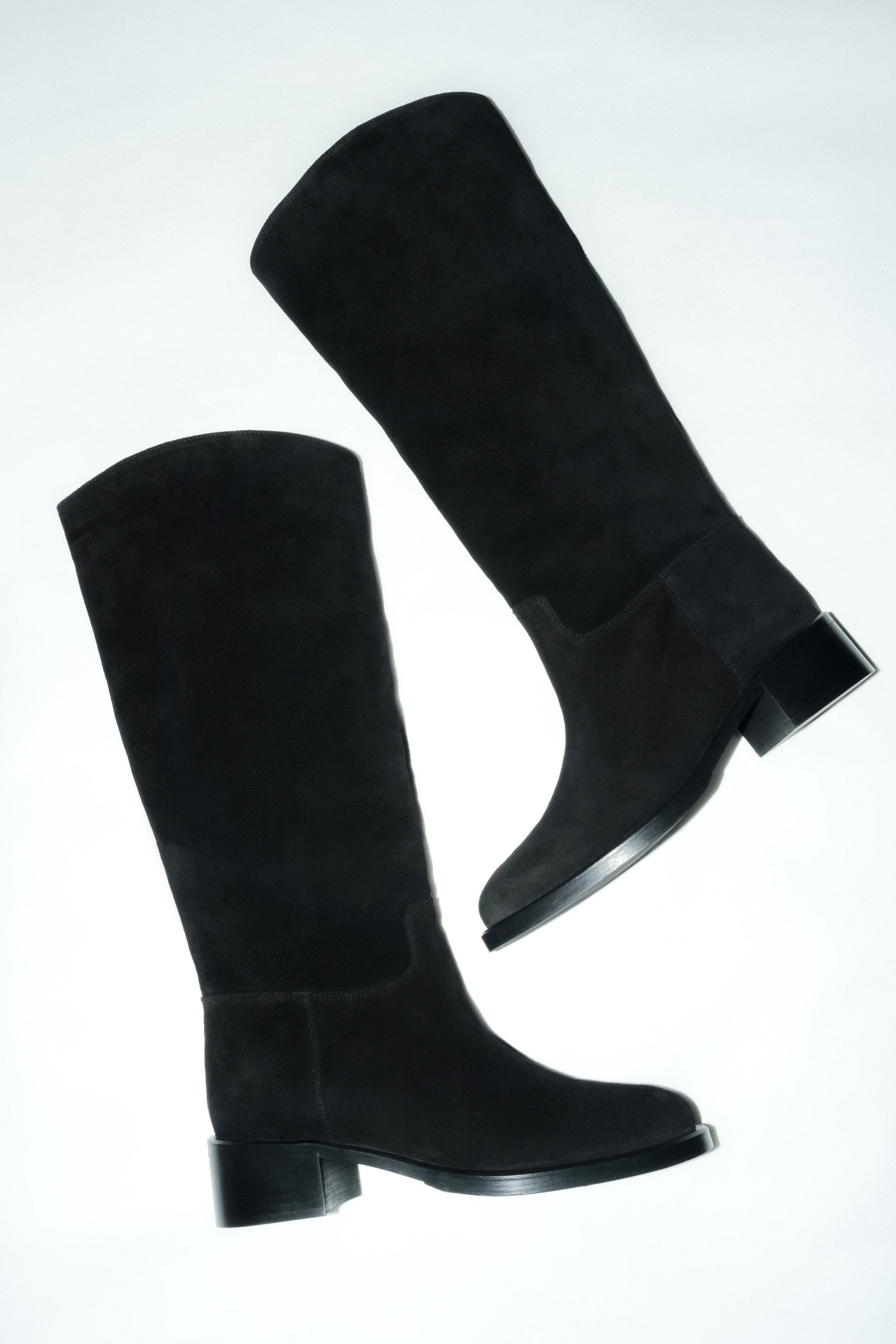 Black women’s knee-high boots made of natural velour on a low heel Estro.