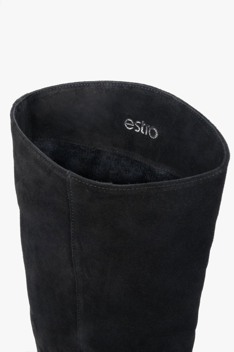 Black women’s knee-high boots made of natural velour on a low heel – details.