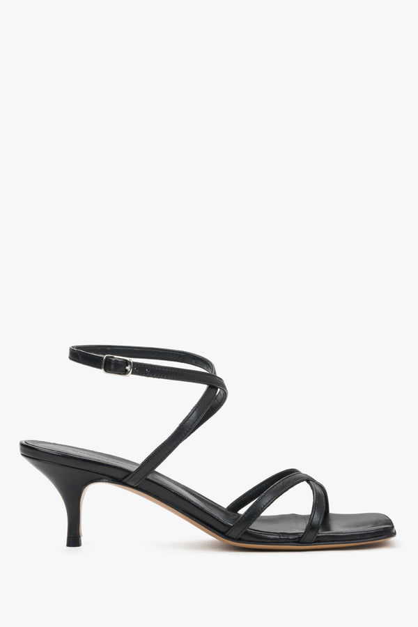 Elegant criss-cross strap sandals in black leather with a modern architectural heel.