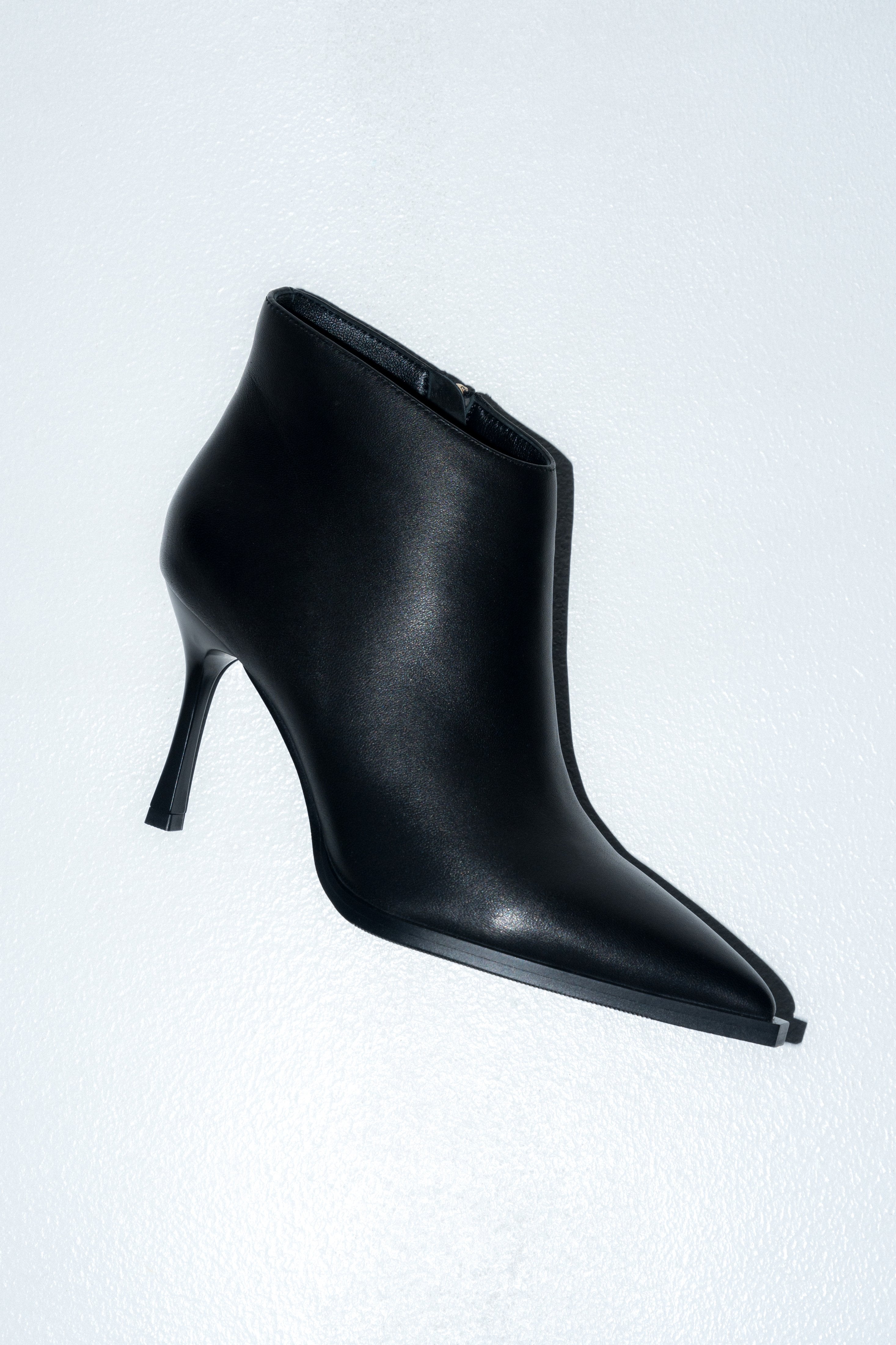 Low black women’s high-heeled ankle boots in genuine leather with a pointed toe.
