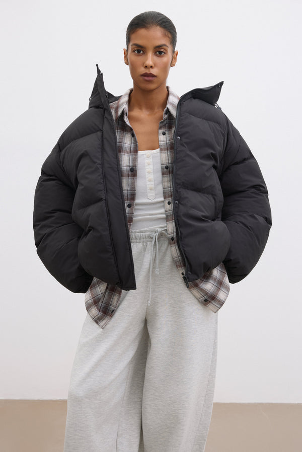Black Women's Oversized Jacket with Detachable Sleeve Feature.