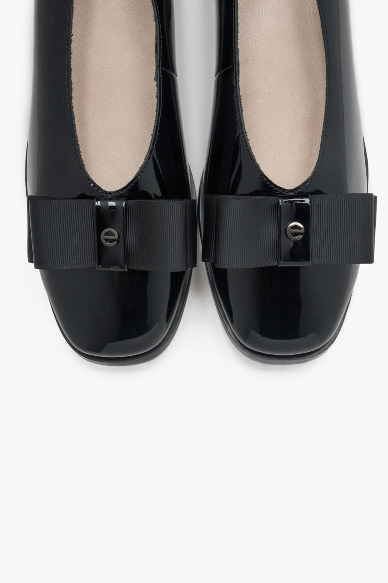 Elegant black women's ballet flats with a bow made of patent natural leather.