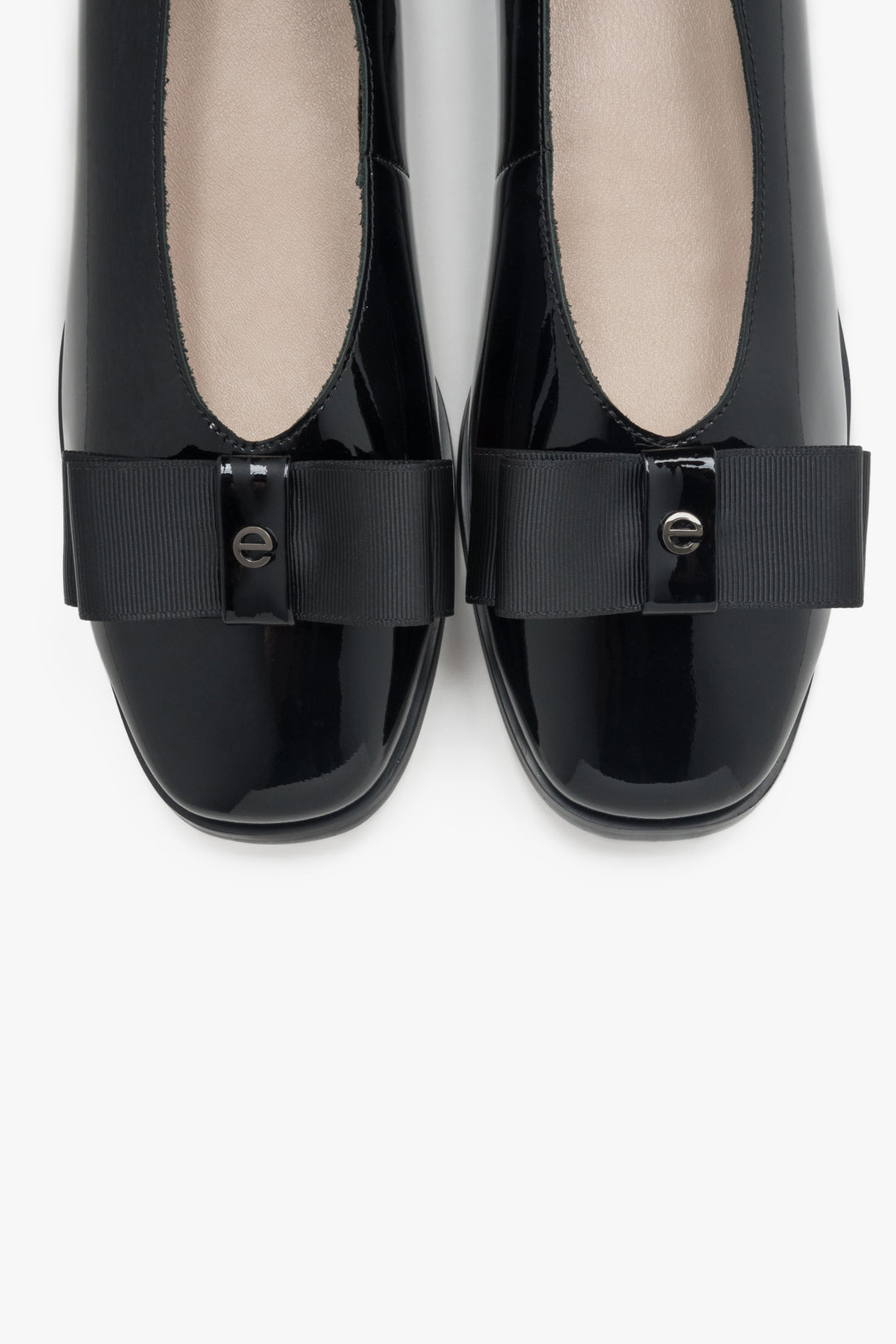 Elegant black women's ballet flats with a bow made of patent natural leather.