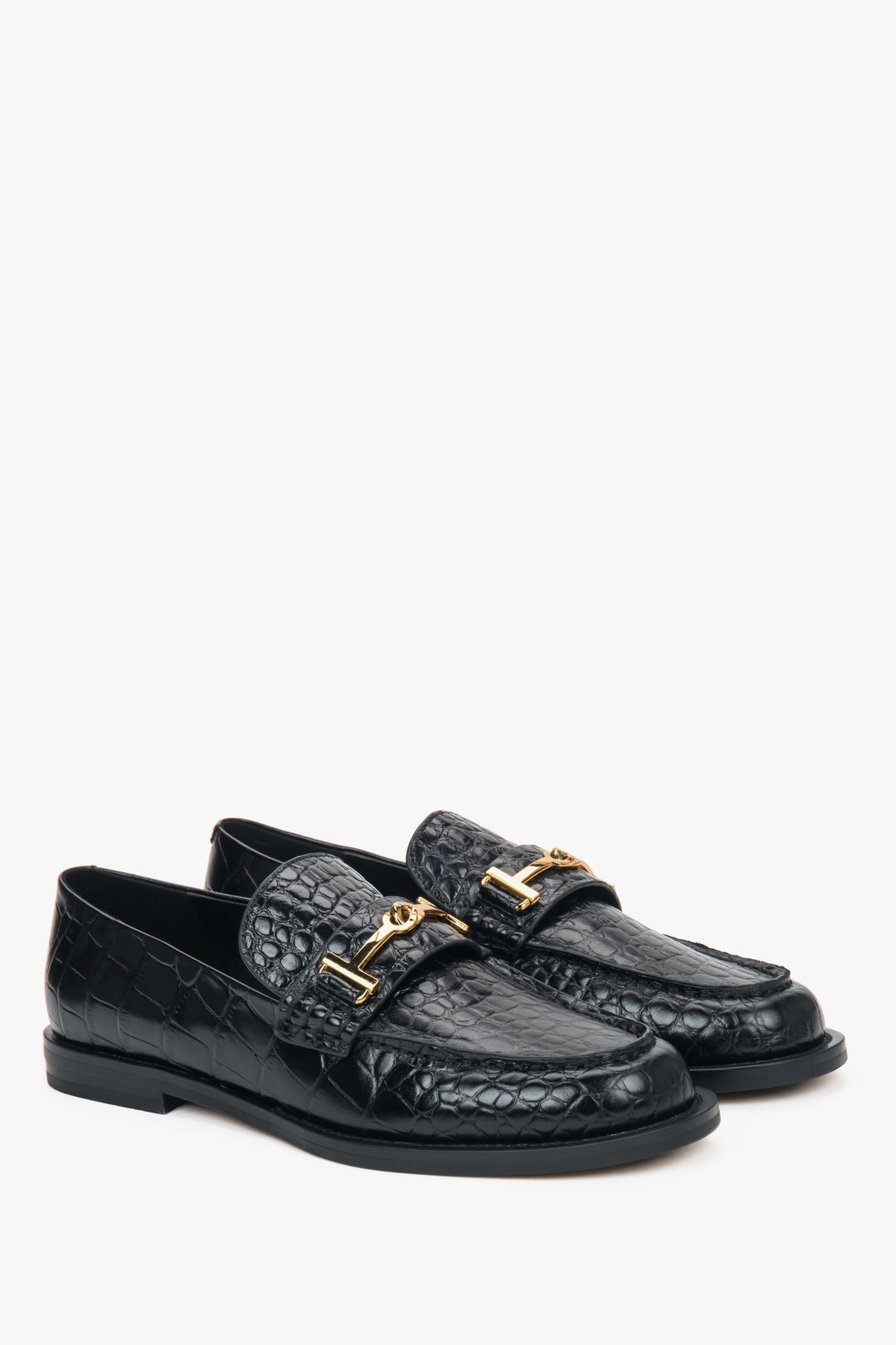 Black women’s patent leather loafers with a decorative buckle.