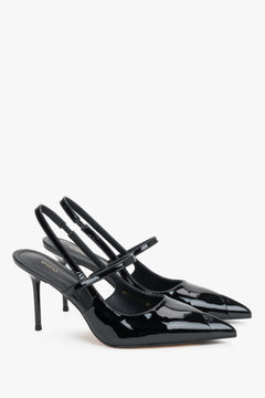 Elegant black patent leather heels featuring a pointed toe and stabilizing foot strap.