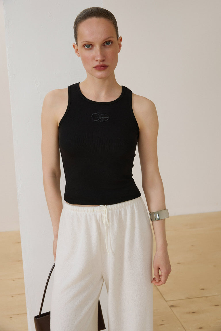 Black sleeveless ribbed cotton top by Estro.