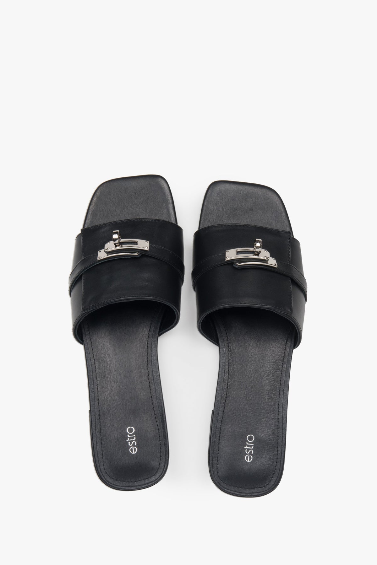 Classic black Estro women's slide sandals, refreshingly accented with a silver embellishment — perfect for summer and comfortable thanks to the flat sole.