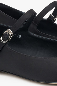 Elegant black flats with buckle detail in textile.