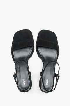 Estro black sandals featuring a low square heel and adjustable ankle strap.
