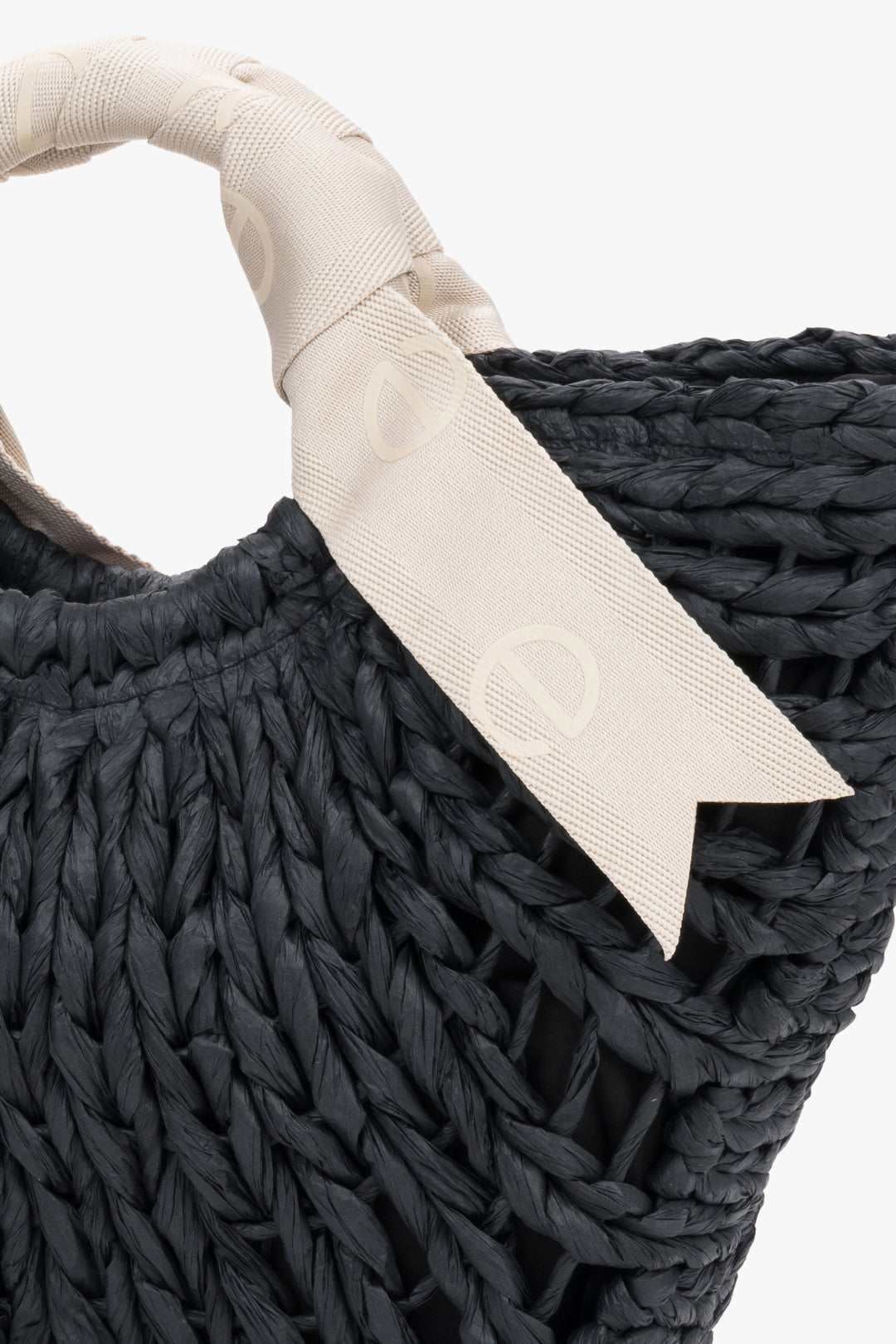 Close-up of black woven texture and white handle.