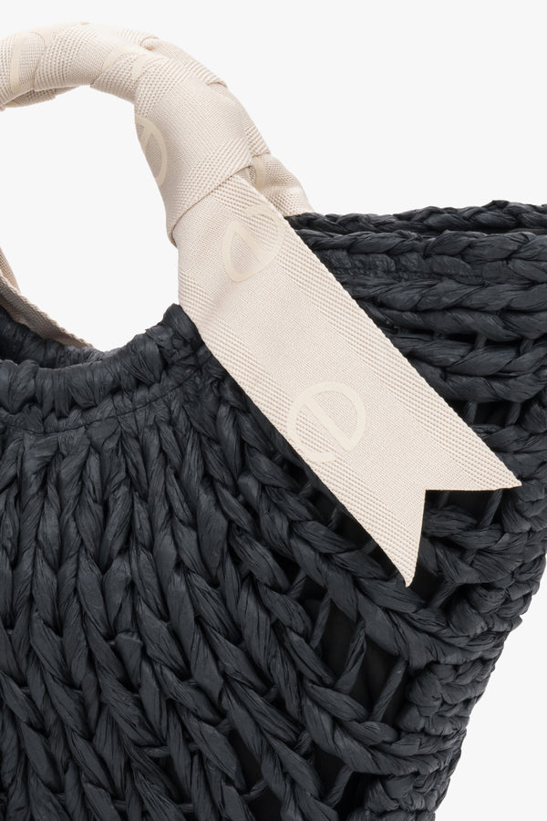 Close-up of black woven texture and white handle.