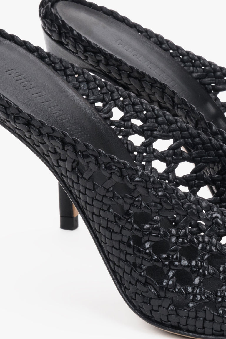 Elegant black woven leather slides featuring an intricate openwork strap and square toe.