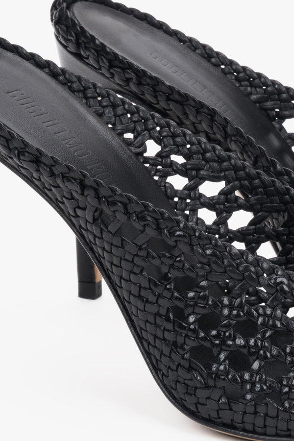 Elegant black woven leather slides featuring an intricate openwork strap and square toe.