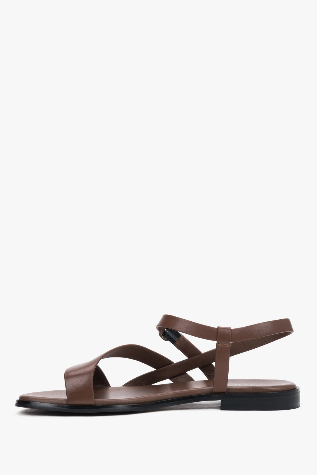 Brown women’s Estro leather sandals with crisscross straps and a flat sole.