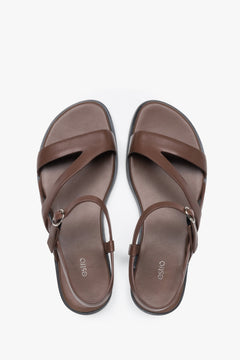 Women’s brown leather Estro sandals with crisscross straps and a flat sole.