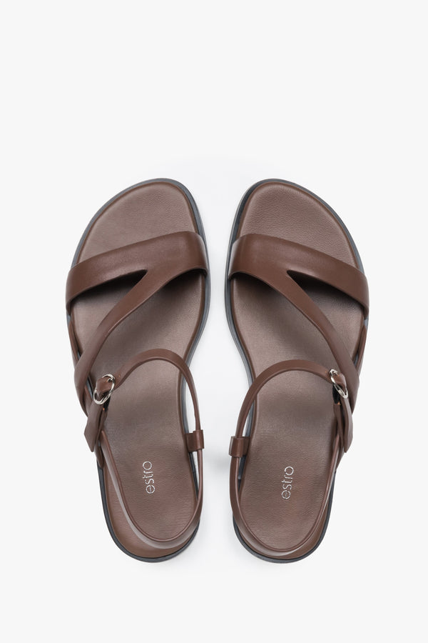 Women’s brown leather Estro sandals with crisscross straps and a flat sole.