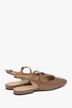 Women's brown patent leather flats with slingback strap.