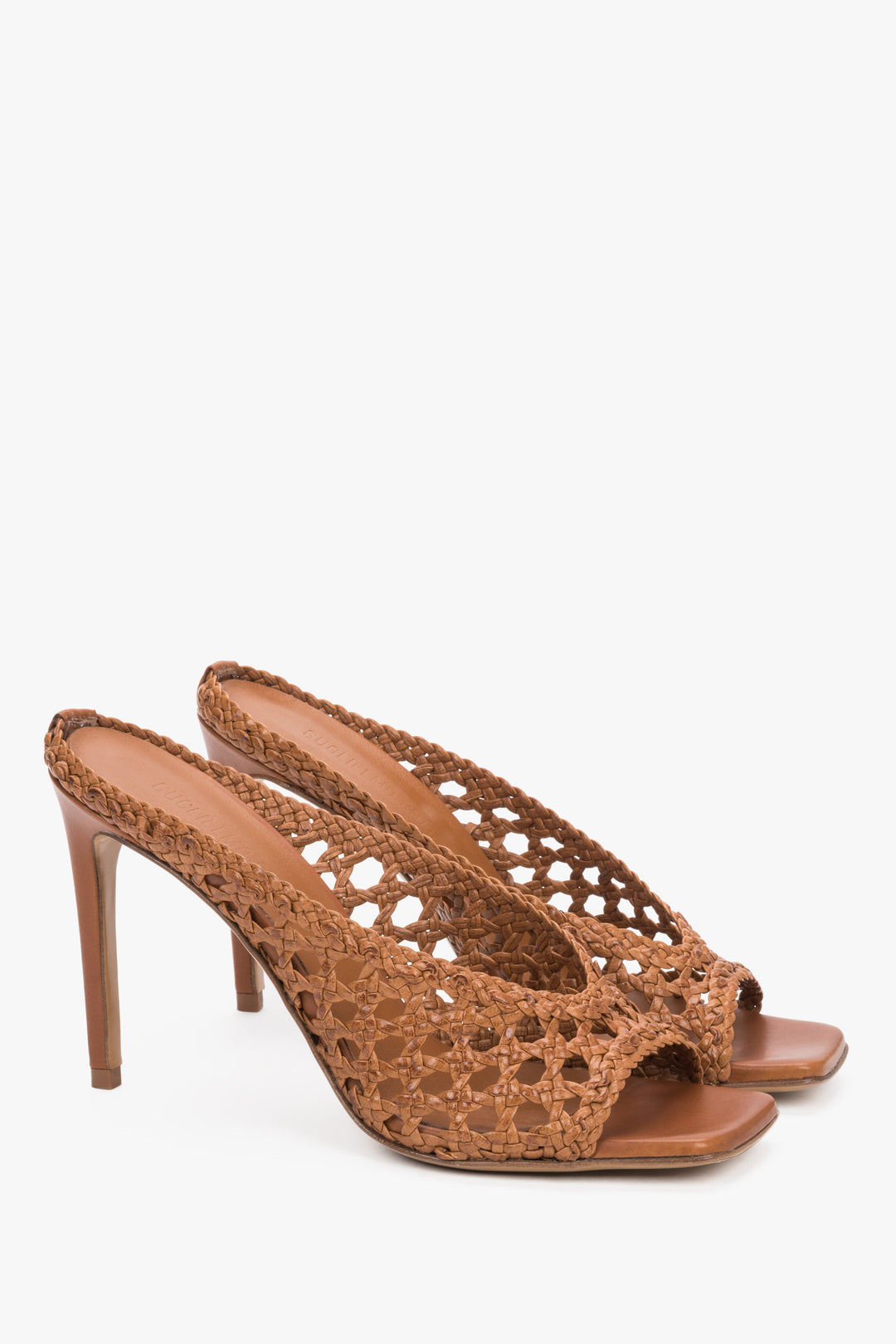Elegant cognac brown leather mules featuring an intricate woven strap and square toe.