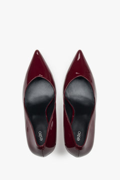 On a high heel, dark red women’s shoes made of patent leather Estro.