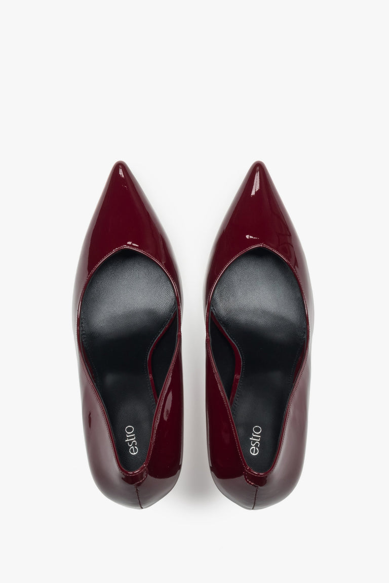 On a high heel, dark red women’s shoes made of patent leather Estro.