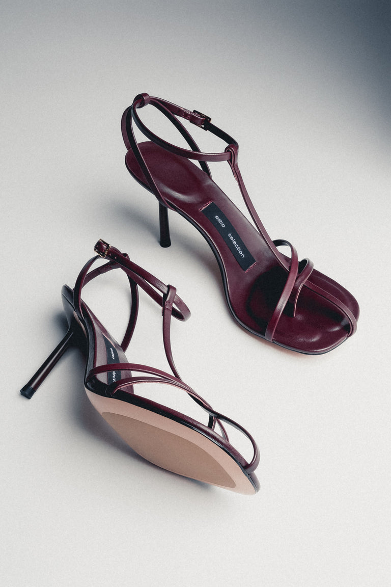 Front angled view of burgundy leather sandals with thin straps