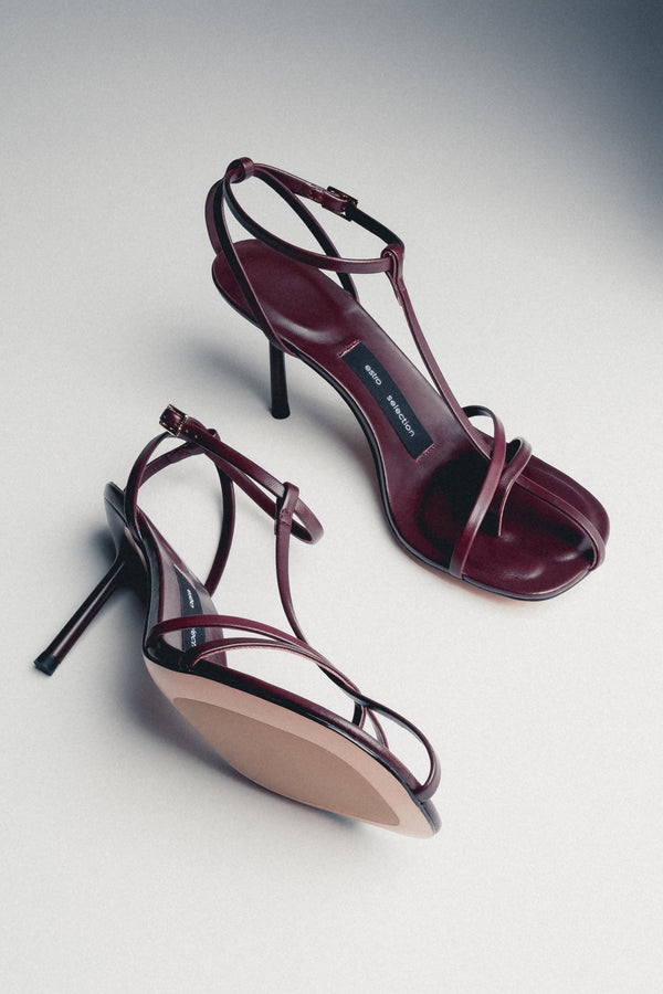 Front angled view of burgundy leather sandals with thin straps