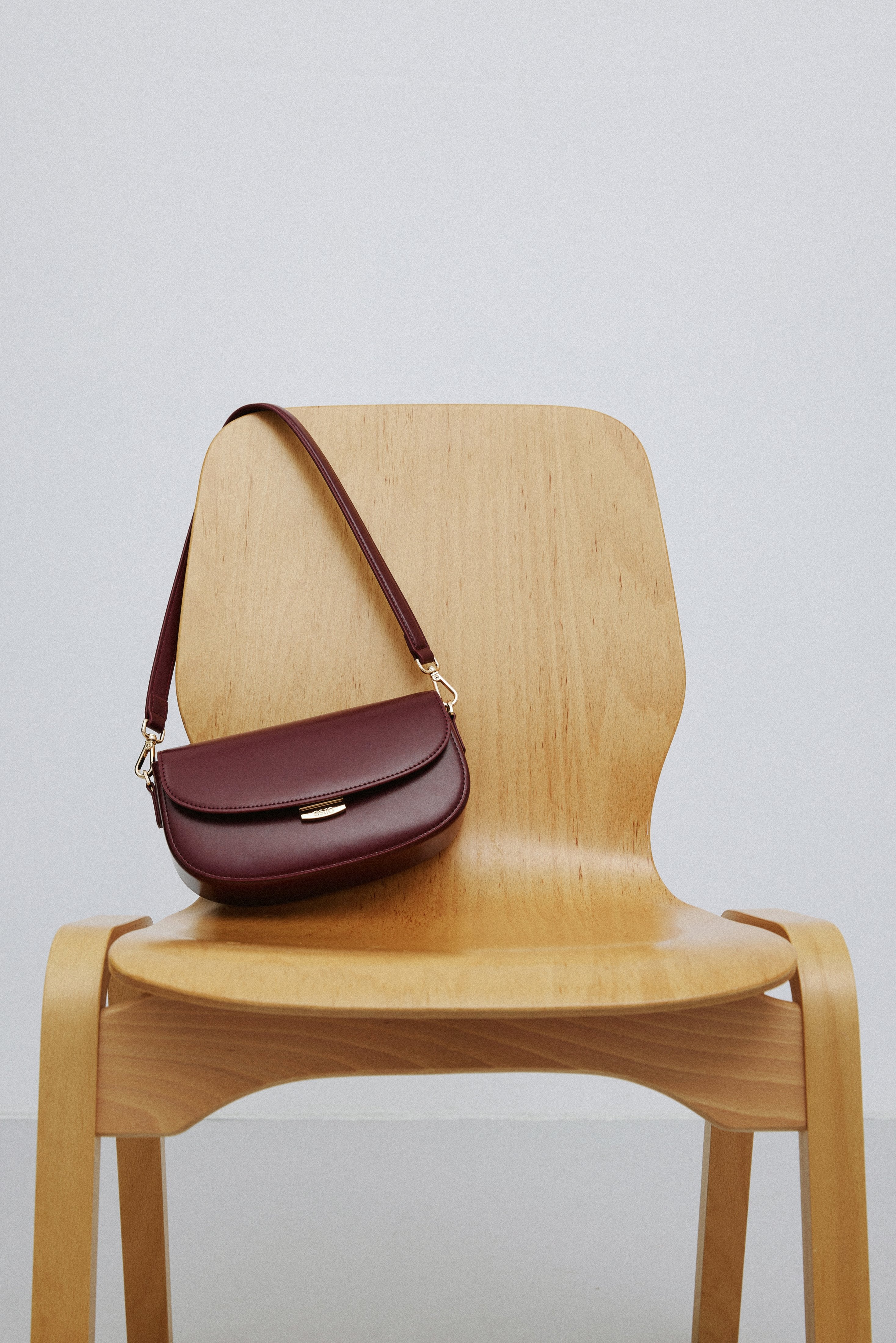 Elegant burgundy leather shoulder bag with a structured silhouette.