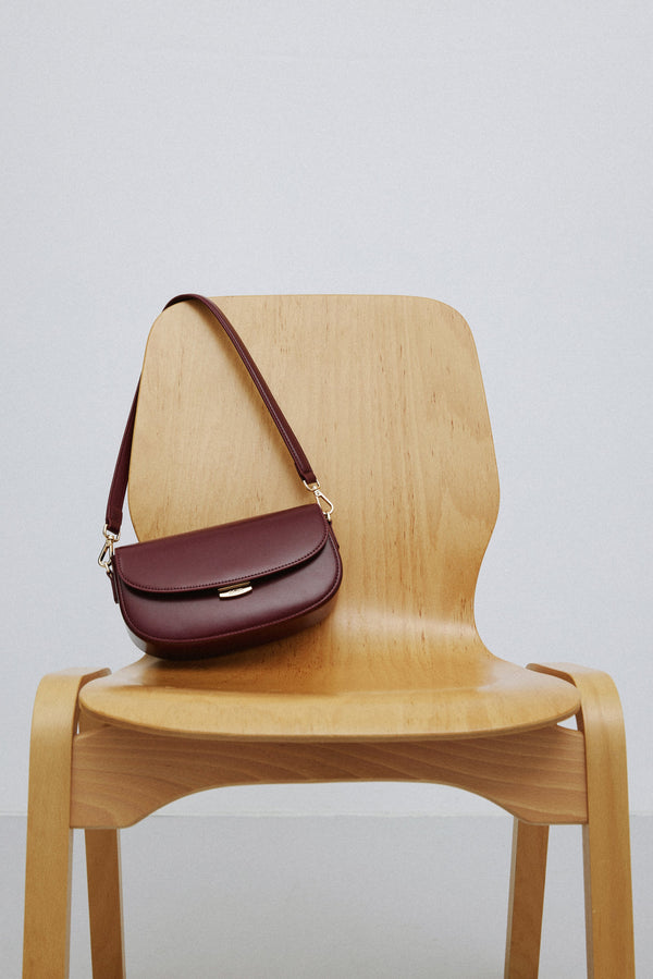 Elegant burgundy leather shoulder bag with a structured silhouette.