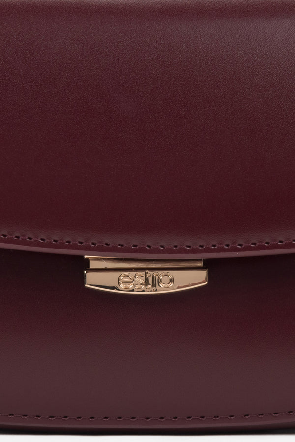 Burgundy leather saddle-style shoulder bag with additional adjustable strap.