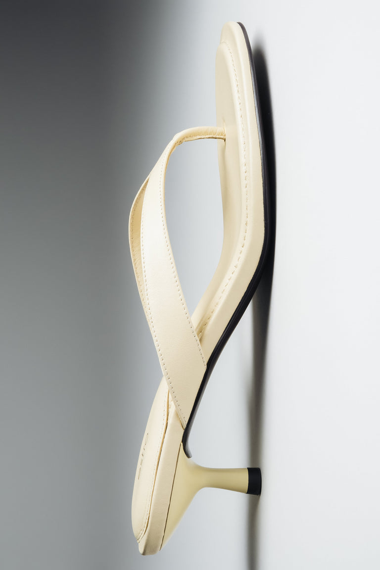 Flat lay view of women's butter yellow leather mules by Estro