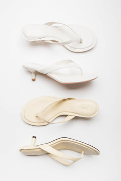 Two light colour versions of women's thong-style mules by Estro