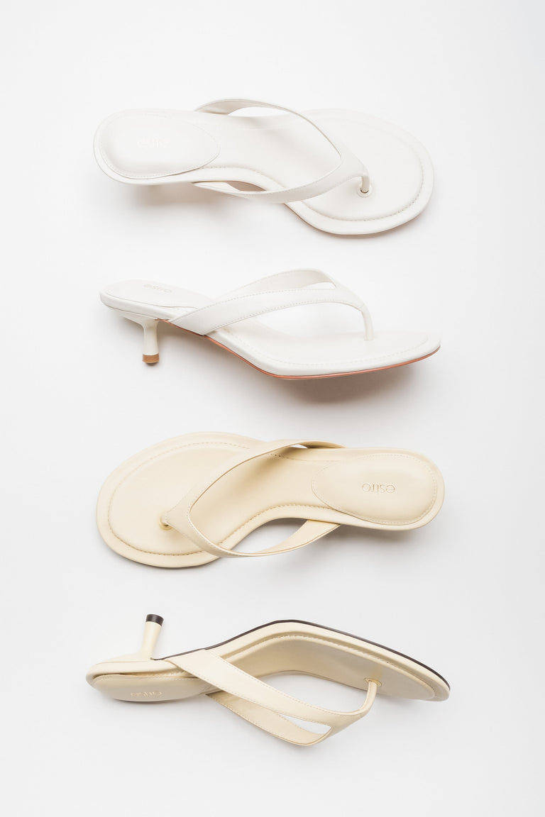 Two light colour versions of women's thong-style mules by Estro
