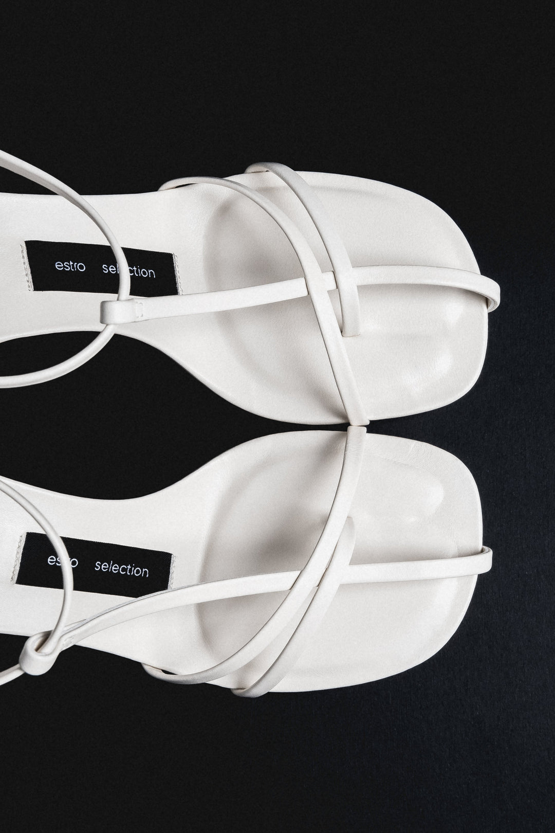 Detail view of delicate straps on cream beige leather sandals