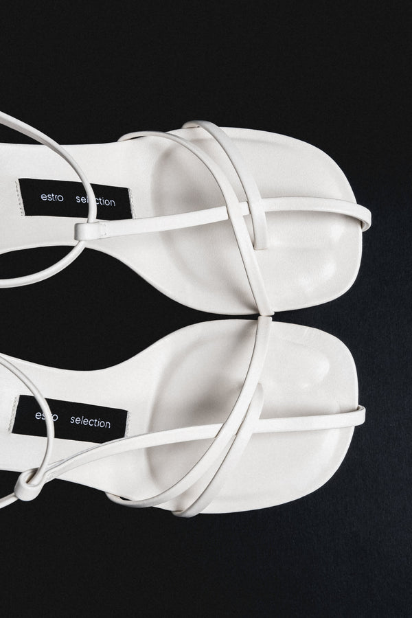 Detail view of delicate straps on cream beige leather sandals