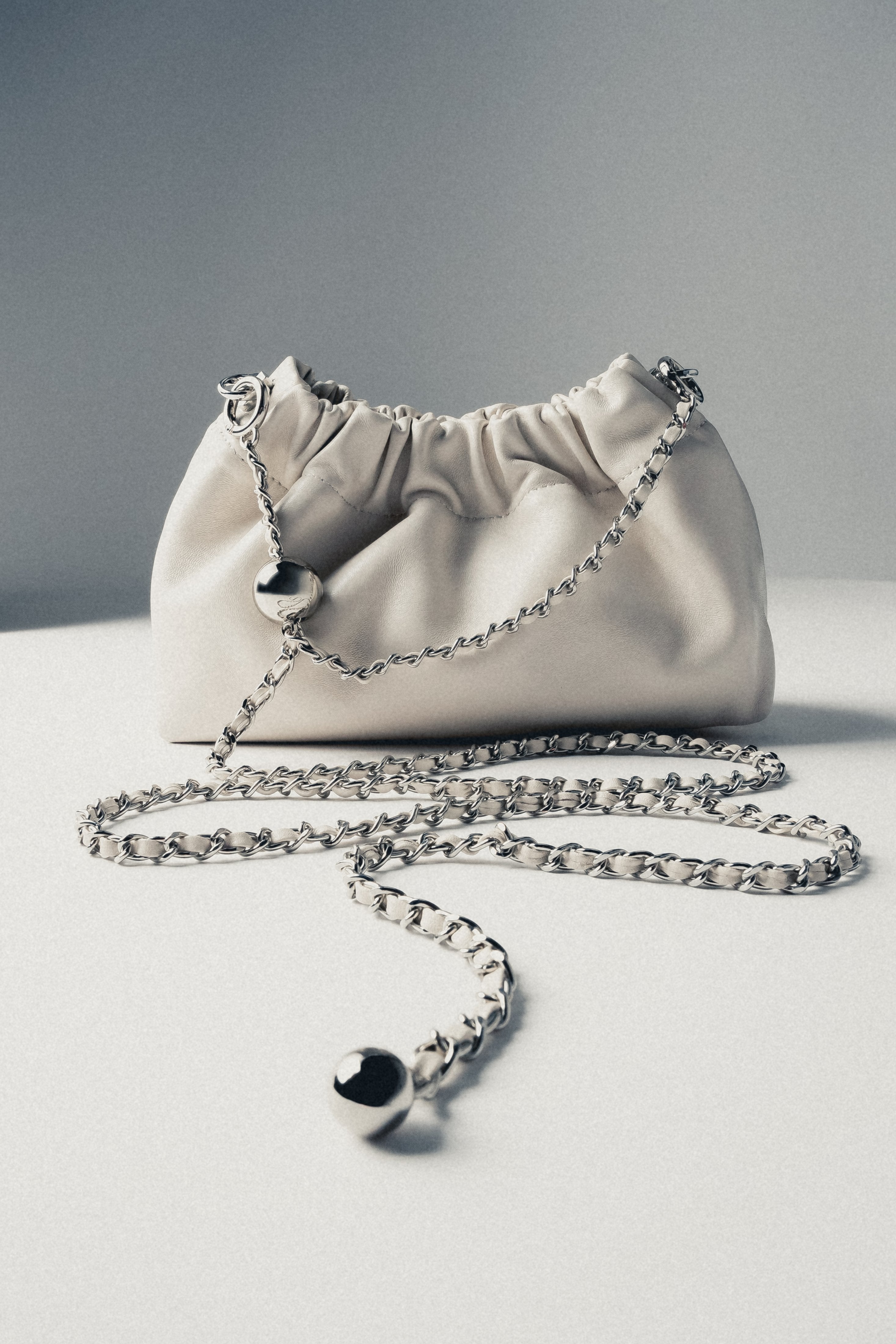 Detail view of women's cream beige leather shoulder bag with chain