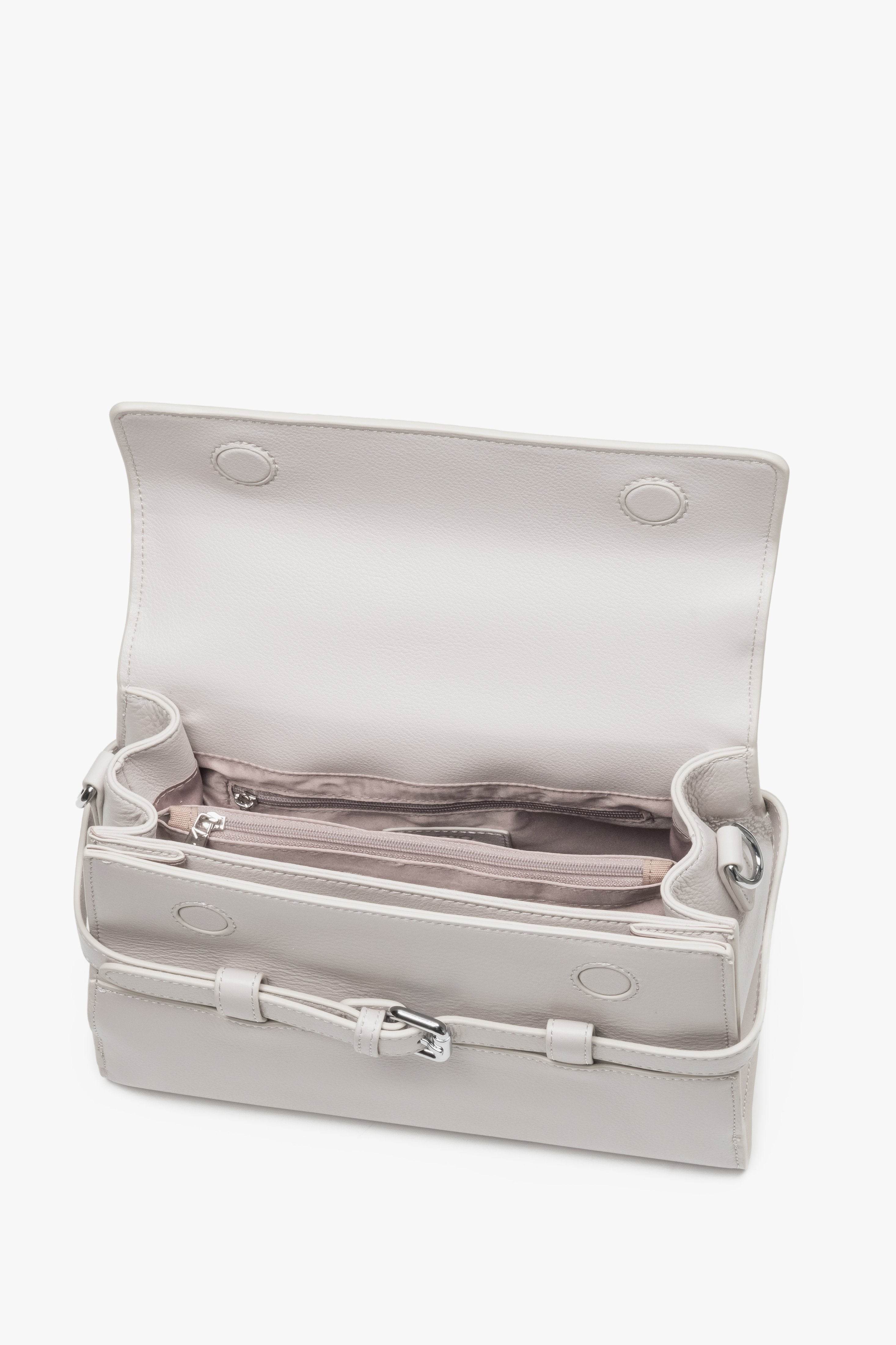 Interior view of women's cream beige leather shoulder bag with compartments.