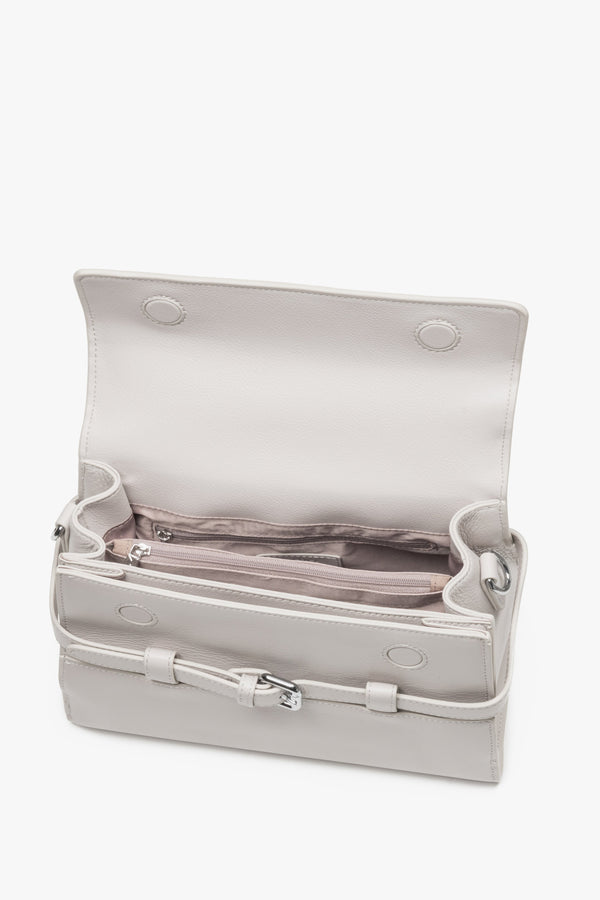 Interior view of women's cream beige leather shoulder bag with compartments.