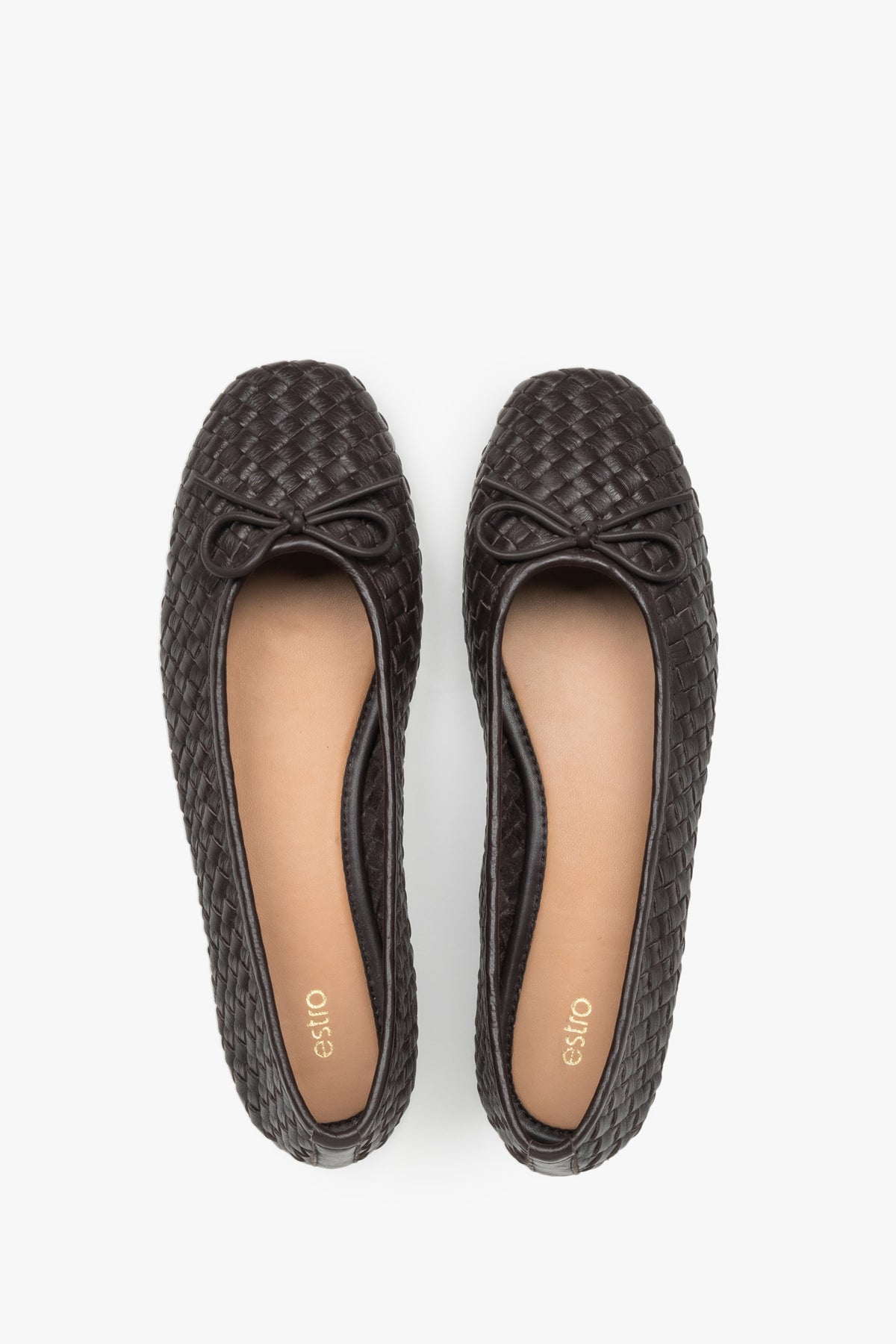 View of a pair of shoes, showcasing a refined toe with a decorative bow and a smooth light-toned leather insole in a contrasting shade.