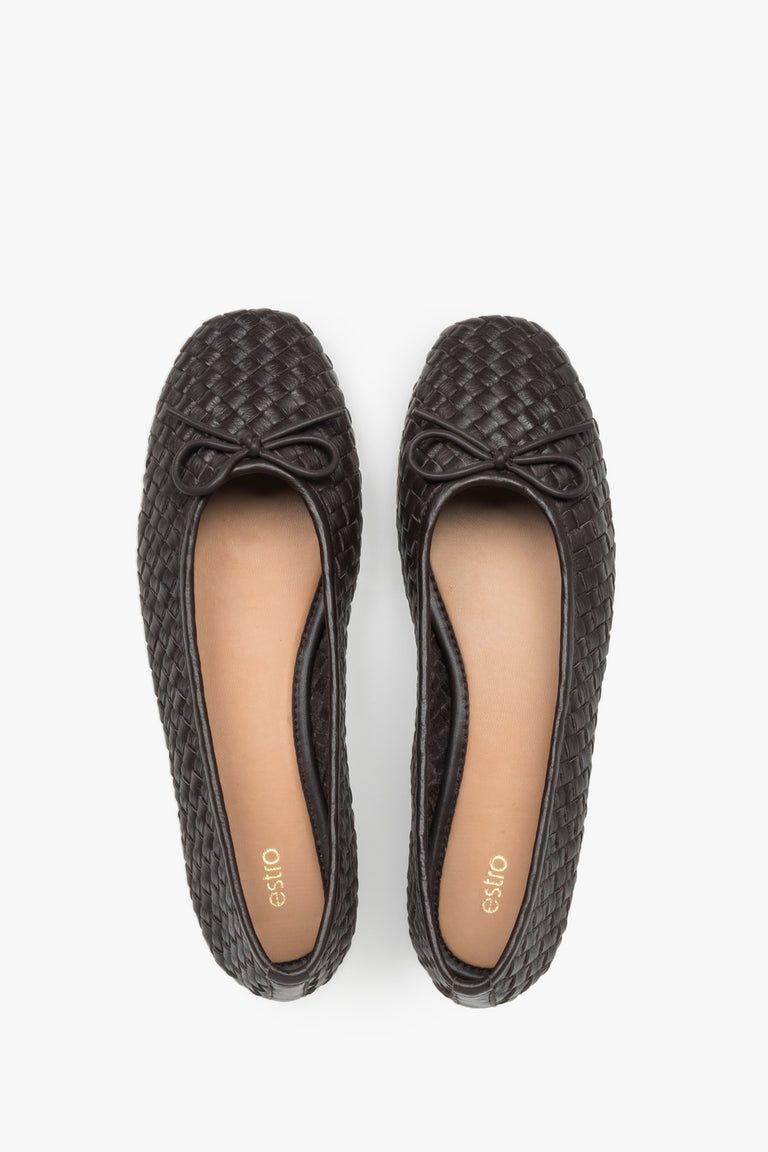 View of a pair of shoes, showcasing a refined toe with a decorative bow and a smooth light-toned leather insole in a contrasting shade.