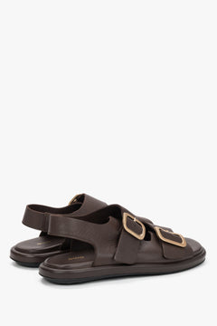 Women’s dark brown Estro flat sandals with adjustable gold-tone buckles.