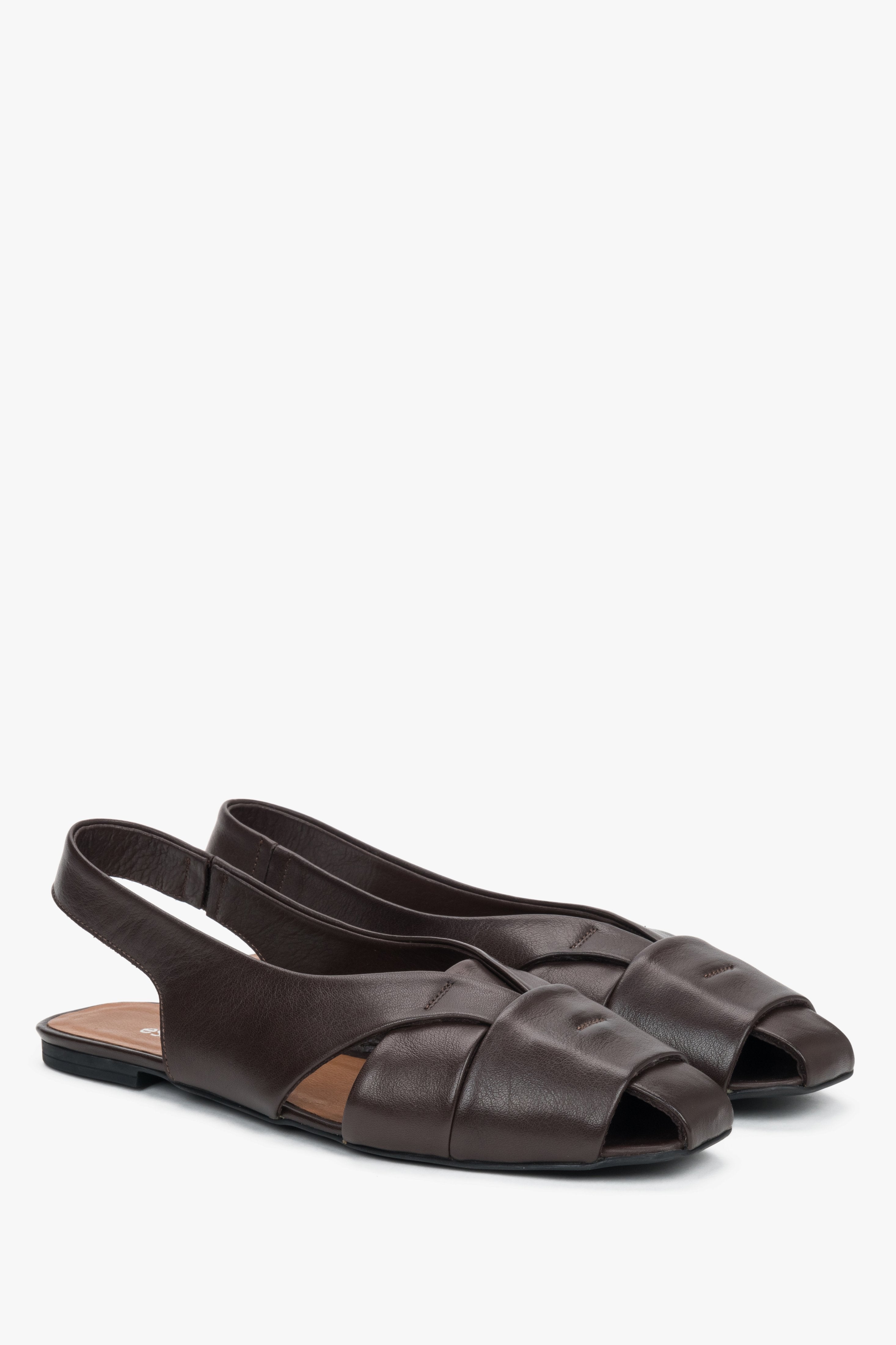 Dark brown leather flat sandals with closed toe.